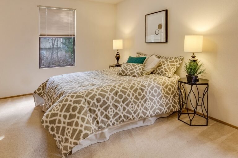 Small bedroom for a couple with matching lamps and nightstands on both sides of the bed