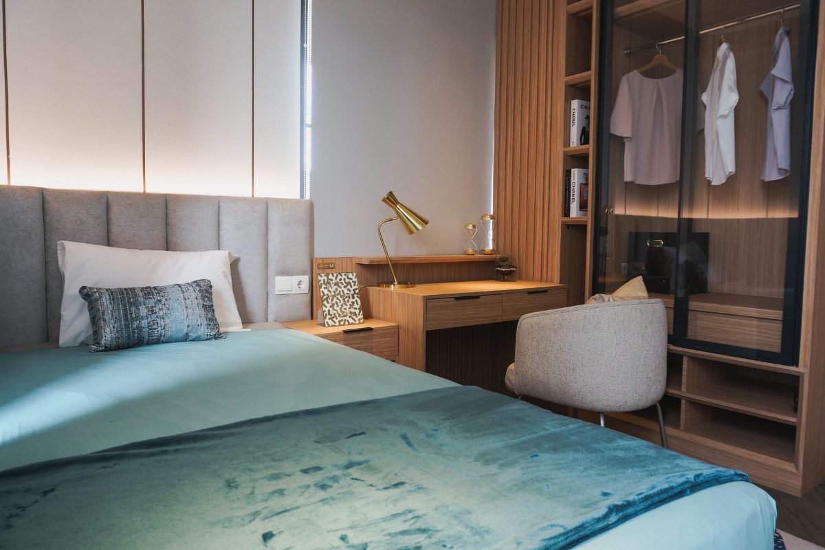 Small cozy teen bedroom with a bed, study desk and built-in closet in warm lighting