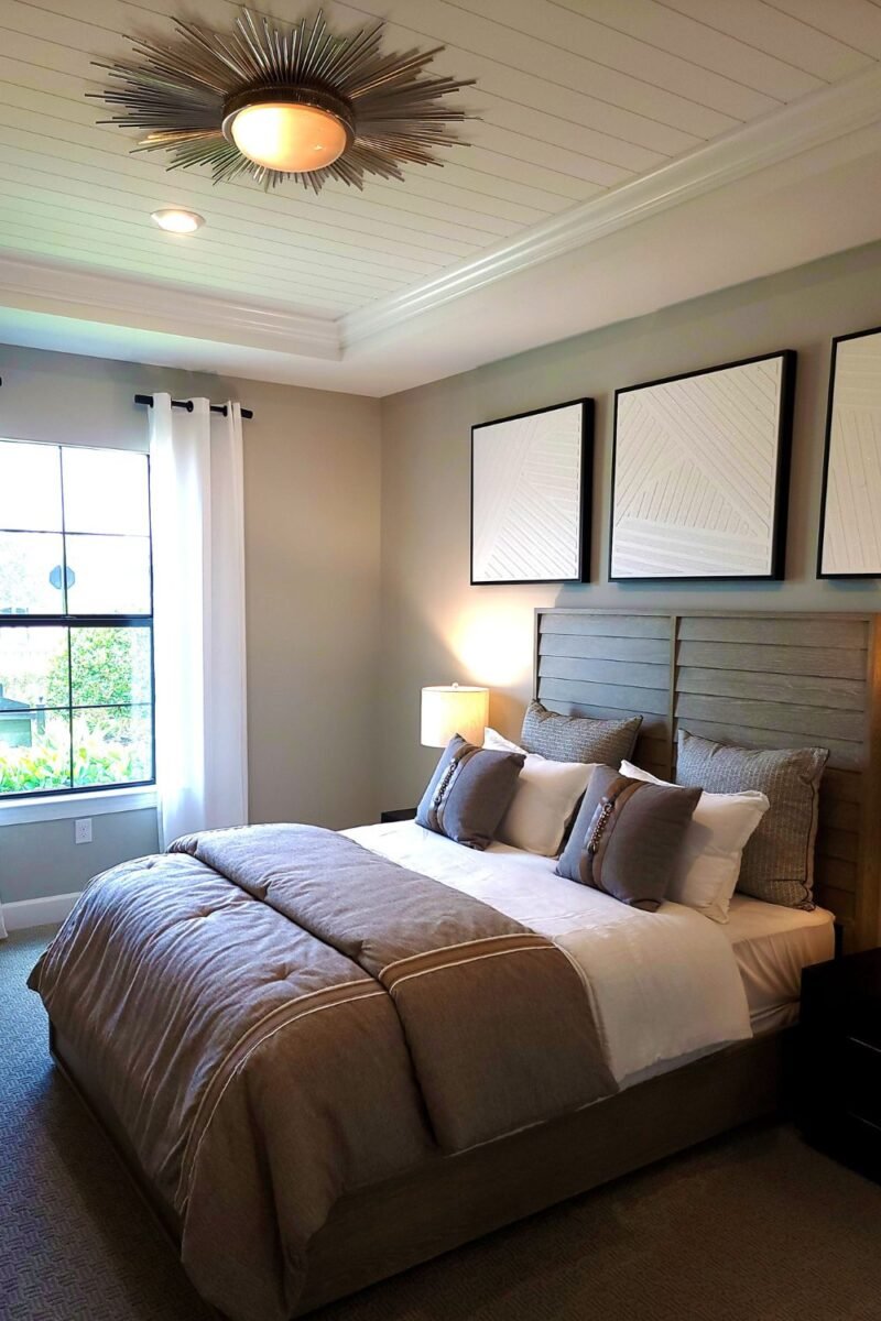 Small couples bedroom with the bed centered under a window and open floor to walk around