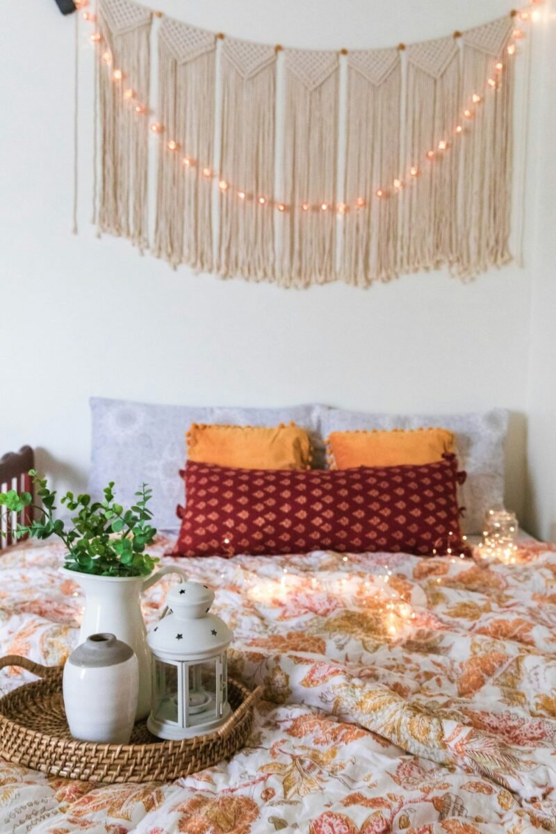 Small bedroom with warm string lights draped above the bed for a cozy glow