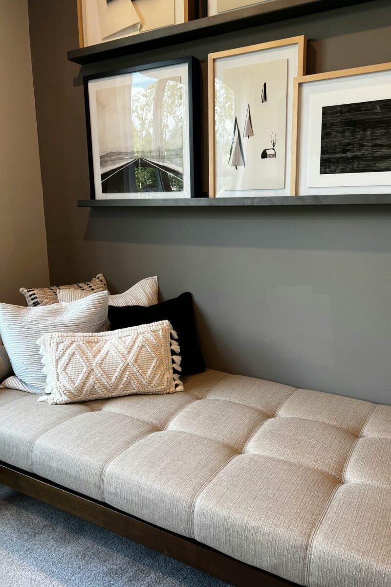 Compact daybed styled as a sofa with cushions against the wall