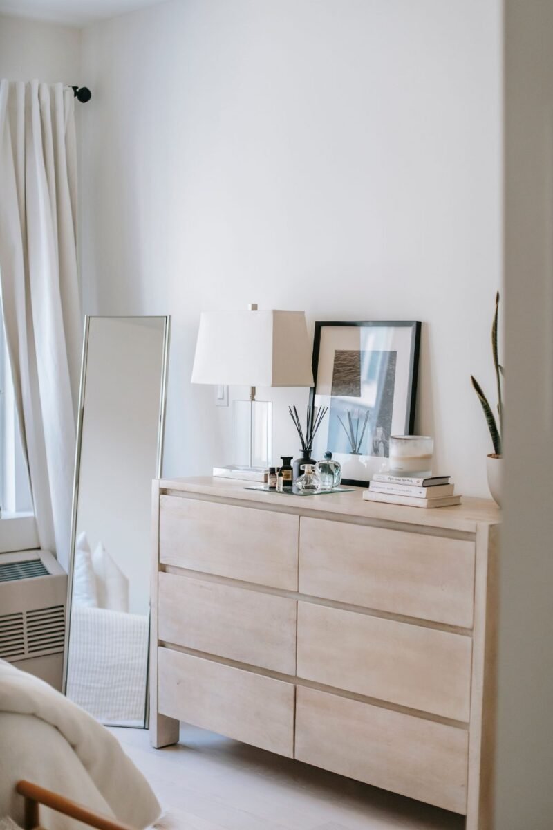 Small guest bedroom with framed art, a mirror, and a potted plant adding warmth