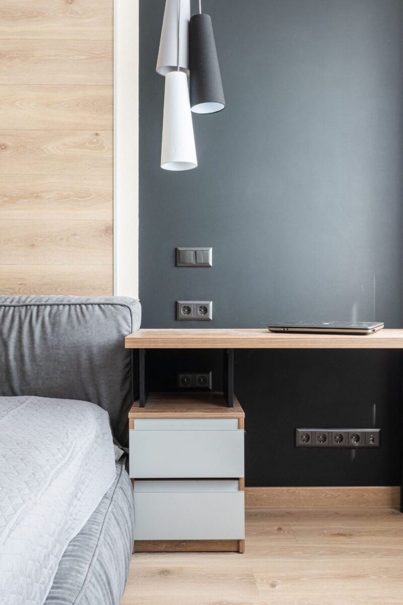 Small guest room that doubles as a home office with a slim desk beside the bed